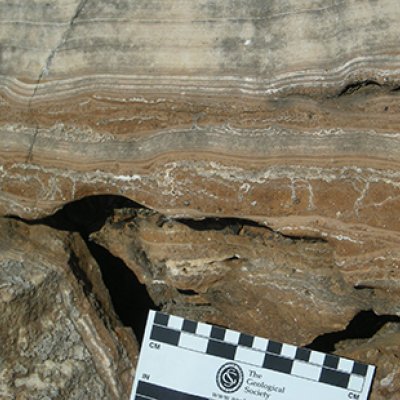 field photograph of massive flowstone layers from one of the South African hominin caves, with red cave sediments underneath. Photo credit: Dr Robyn Pickering 